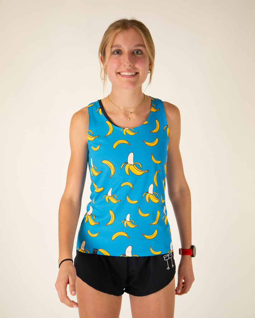 Runner is wearing ChicknLegs in the women's performance singlet in the blue banana design. The print has a solid blue background with yellow bananas all over it.