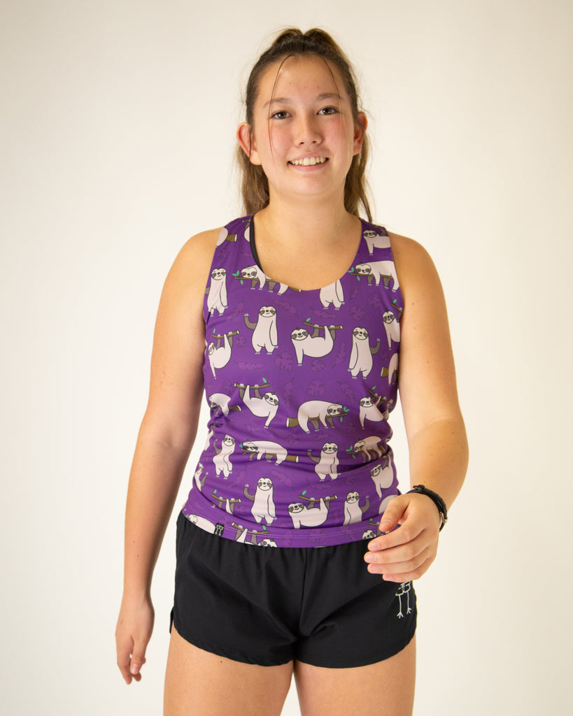 Runner is wearing ChicknLegs in the women's performance singlet in the sloth design. The print has sloths all over it with a purple background and leaves.